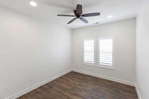 Empty room with dark wood-type flooring, a ceiling fan, and recessed lighting
