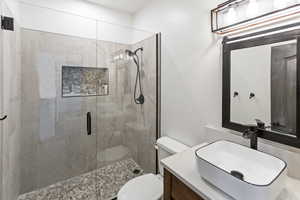 Bathroom featuring vanity, a stall shower, and a textured wall