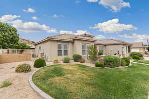 Back of house featuring stucco siding, a tile roof, and a gate
