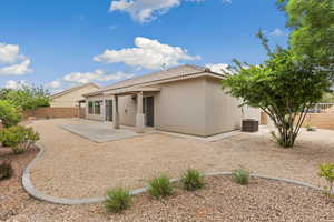 Back of property featuring a fenced backyard, a patio, stucco siding, and a tiled roof