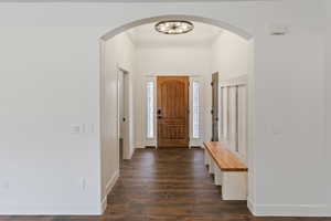 Entrance foyer featuring dark wood-style floors and arched walkways