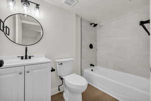 Bathroom with vanity, shower / bathtub combination, and light wood-style floors