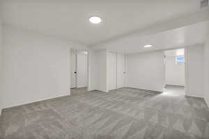 Basement with light carpet and baseboards
