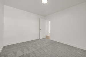 Spare room with carpet and baseboards