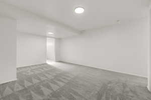 Carpeted spare room with baseboards