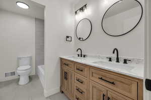 Bathroom featuring double vanity and toilet