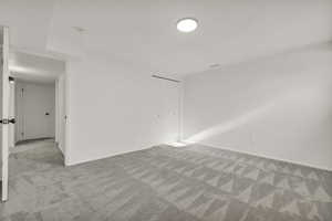 Unfurnished bedroom featuring a closet and light colored carpet