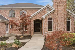 View of front of home featuring roof with shingles and brick siding