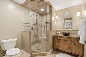Full bath with vanity, a shower stall, and light tile patterned floors