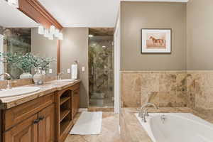 Full bathroom featuring double vanity, a stall shower, and a garden tub