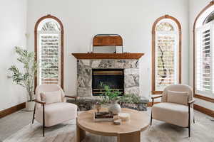 Sitting room with a stone fireplace and carpet