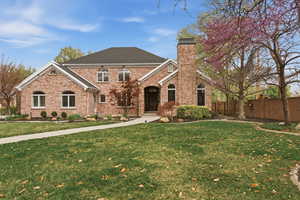 View of front of property featuring brick siding and a chimney