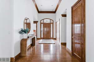 Foyer entrance featuring dark wood-type flooring and ornamental molding
