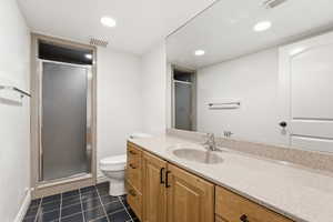 Full bath featuring a stall shower, vanity, recessed lighting, and dark tile patterned floors