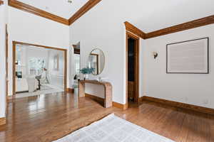 Entryway featuring ornamental molding, light wood-type flooring, and a fireplace