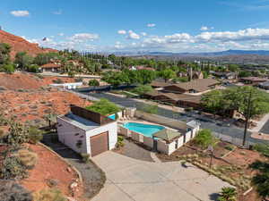 Aerial view of residential area featuring a mountain backdrop and a pool area