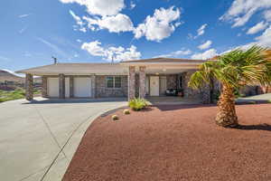 Ranch-style house featuring an attached garage, driveway, brick siding, and a mountain view