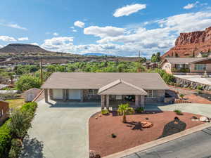 Single story home featuring a mountain view, stone siding, a tile roof, and driveway