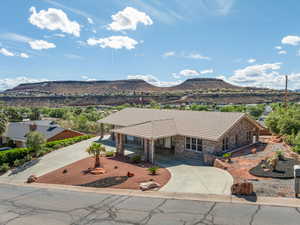 View of front of home featuring a mountain view, stone siding, driveway, and a tile roof