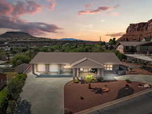 View of front of home featuring stone siding, a tile roof, driveway, and a mountain view