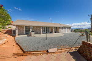 Back of house with brick siding, a fenced backyard, and a patio area