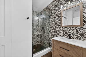 Full bathroom with a tile shower and vanity