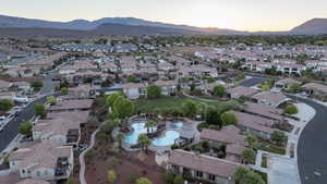 Aerial view at dusk of a residential view, a mountain view, and view of pool area
