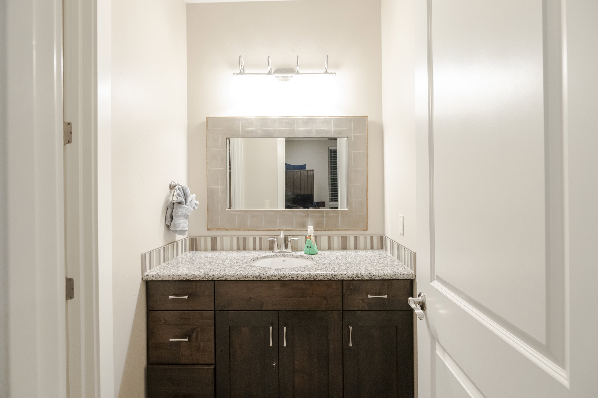 Bathroom with vanity and tasteful backsplash