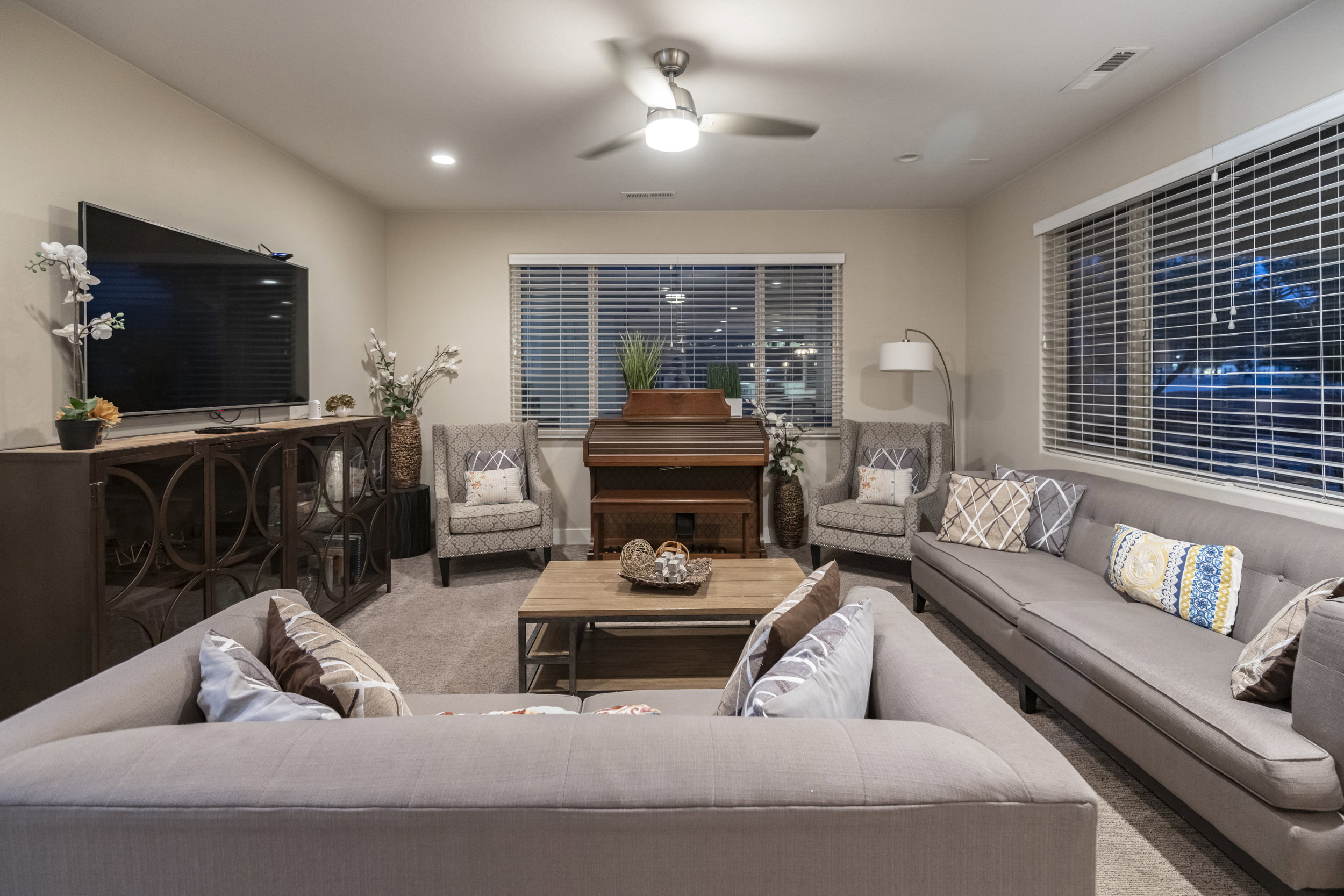 Living area featuring ceiling fan and carpet flooring