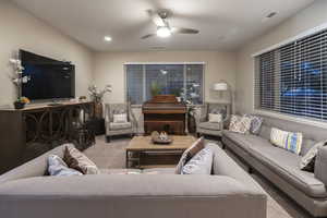 Living area featuring ceiling fan and carpet flooring