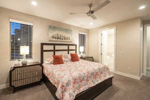 Bedroom with light carpet, ceiling fan, recessed lighting, and ensuite bath