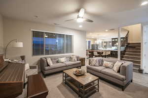 Living area featuring ceiling fan, suspended lighting, and wood finished floors