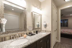 Full bathroom featuring ensuite bathroom, double vanity, recessed lighting, and wood tiled floors