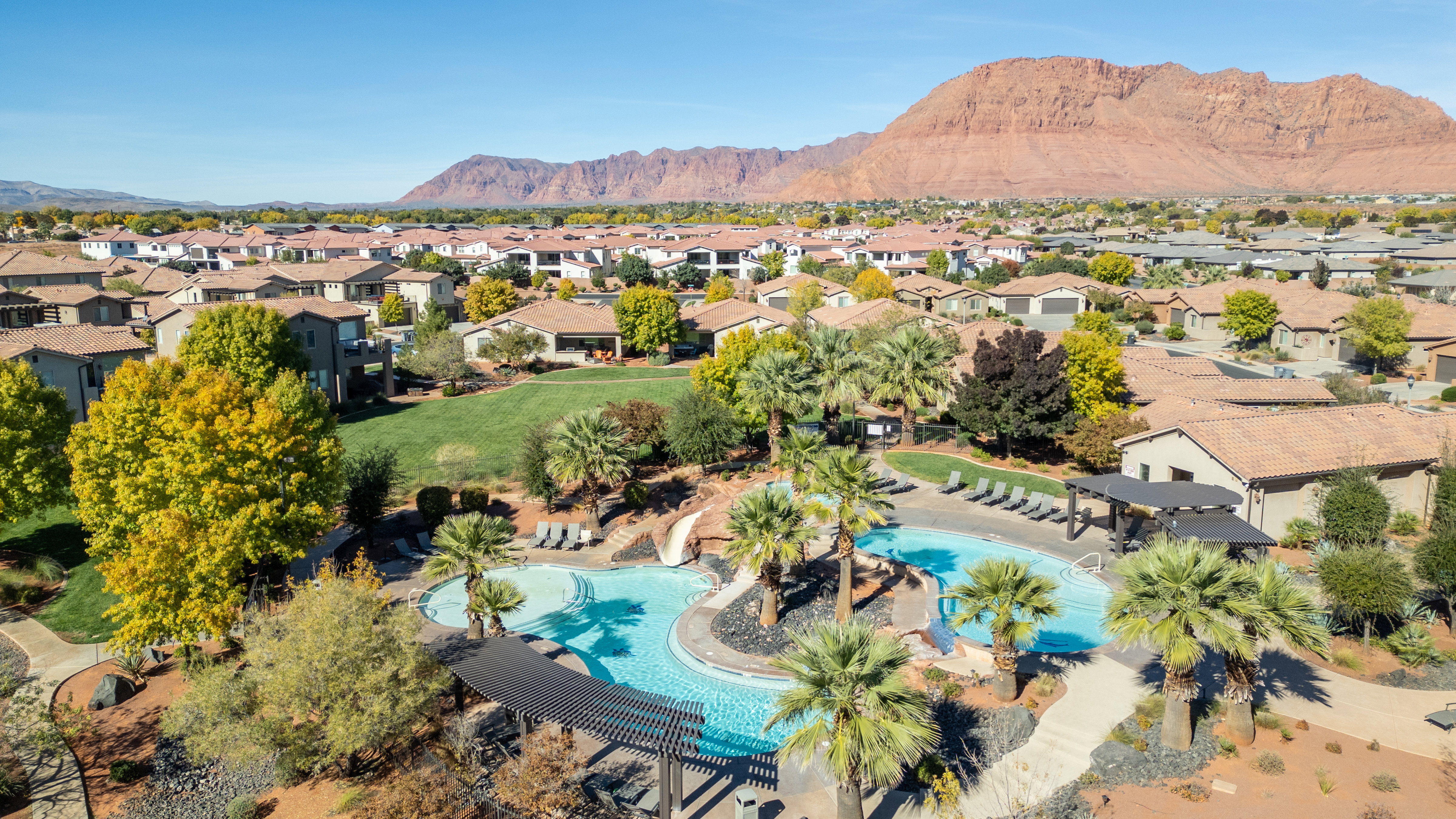 Aerial perspective of suburban area with mountains and a pool
