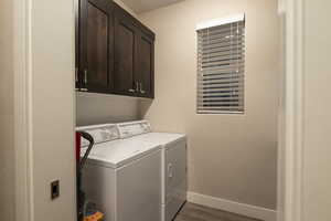 Laundry room with light wood-style flooring, independent washer and dryer, and cabinet space
