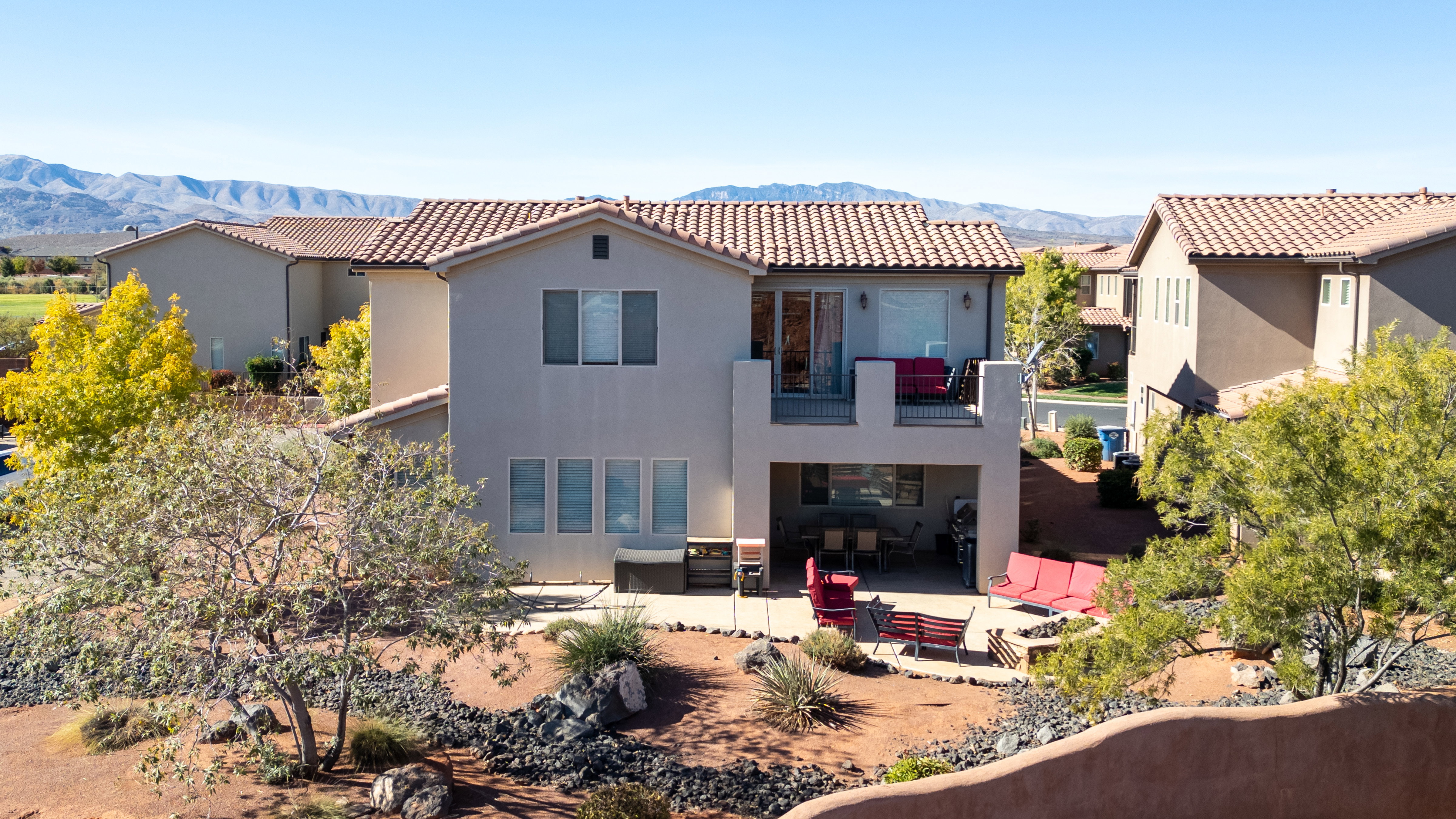 Back of house featuring outdoor furniture, stucco siding, a mountain view, a patio area, and a tiled roof