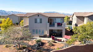Back of house featuring outdoor furniture, stucco siding, a mountain view, a patio area, and a tiled roof