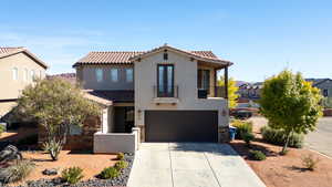 Mediterranean / spanish-style home featuring a balcony, a garage, driveway, stucco siding, and a tile roof