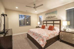Bedroom featuring light colored carpet, a ceiling fan, and recessed lighting