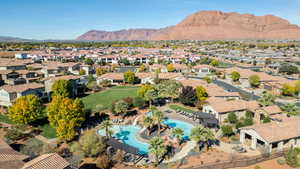 Aerial view of residential area featuring a mountain backdrop and a pool