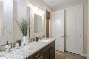 Full bath with double vanity and light wood finished floors