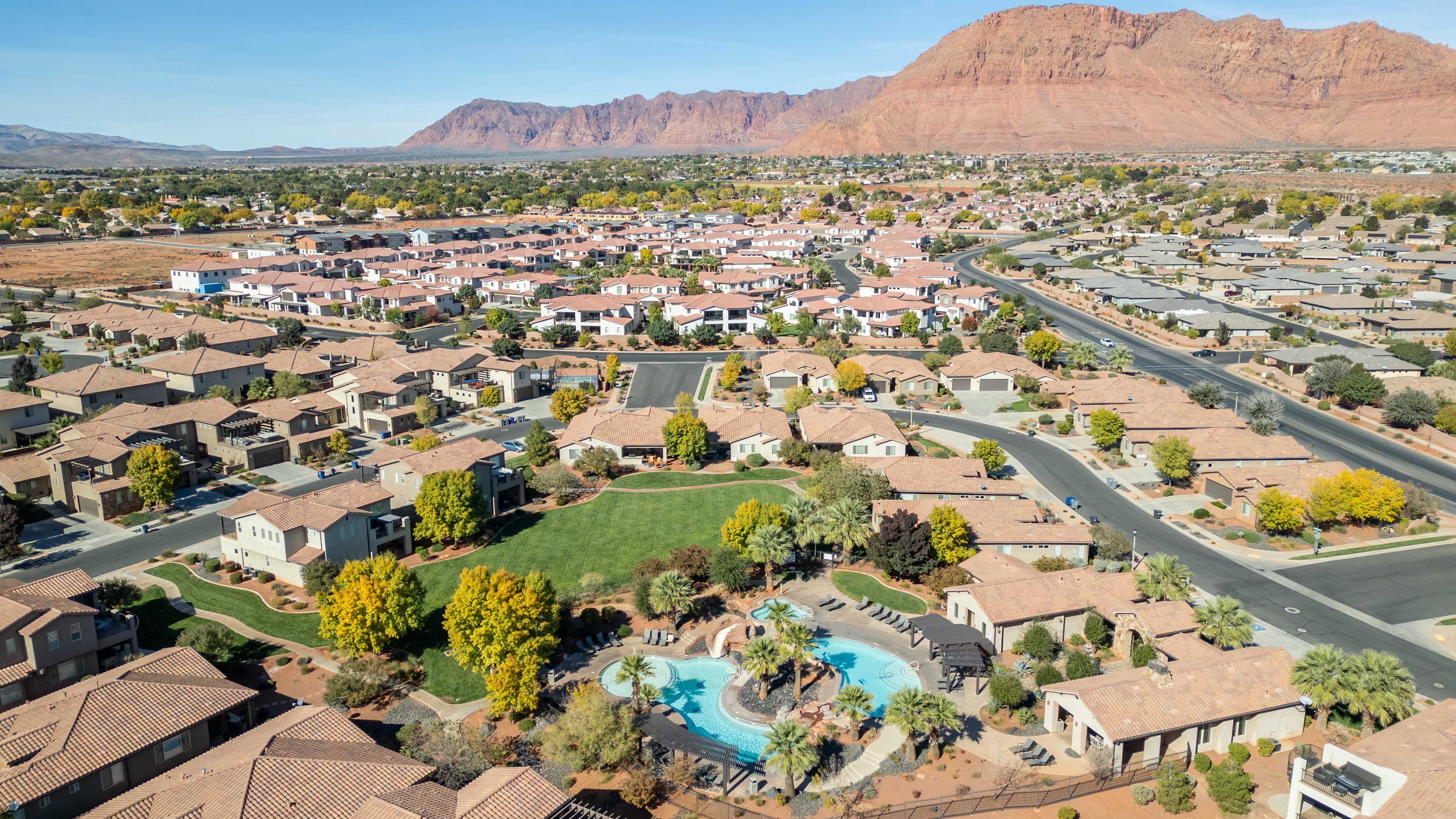 Aerial perspective of suburban area with mountains and a pool area