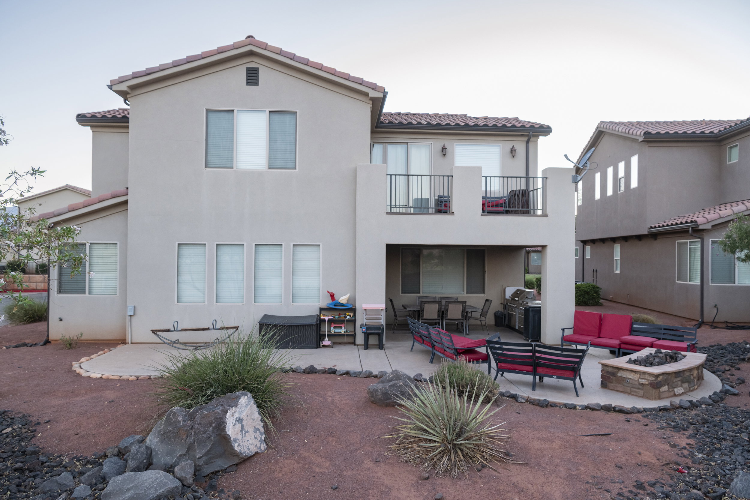 Rear view of property featuring a patio area, an outdoor living space with a fire pit, a tile roof, and stucco siding