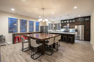 Dining room with wood tiled floors and suspended lighting