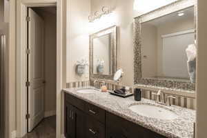 Full bath featuring double vanity and wood finished floors
