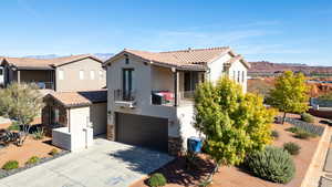 Mediterranean / spanish-style home with a mountain view, a balcony, a garage, stucco siding, and driveway