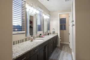 Bathroom with double vanity and light wood-style floors