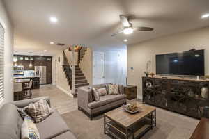 Living area with ceiling fan, recessed lighting, and light wood-style flooring