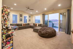 Living room with lofted ceiling, carpet floors, a ceiling fan, recessed lighting, and a mountain view