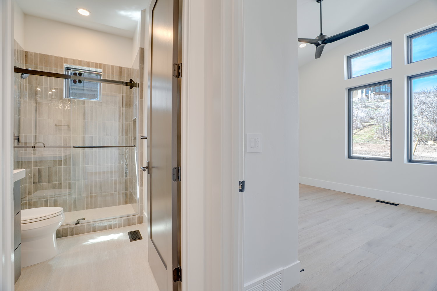 Bathroom with a ceiling fan, a stall shower, light wood-type flooring, and recessed lighting